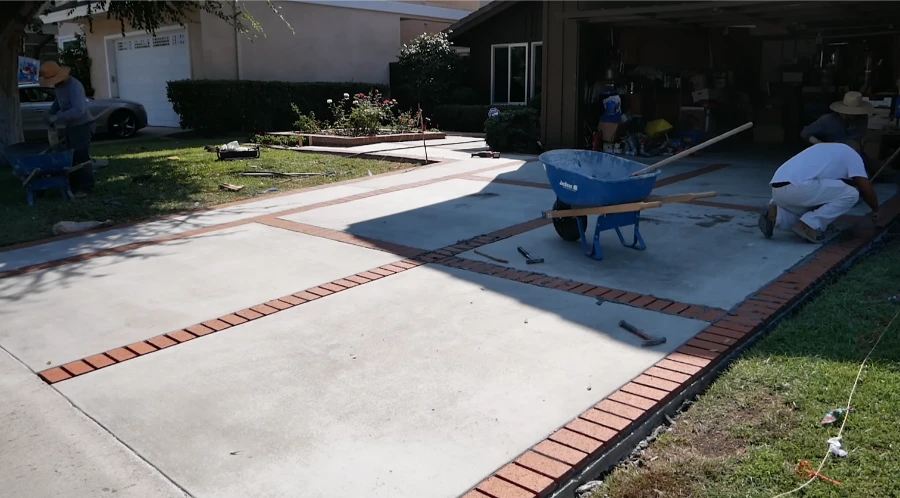 Kansas City driveway contractors installing concrete with decorative brick border inlay